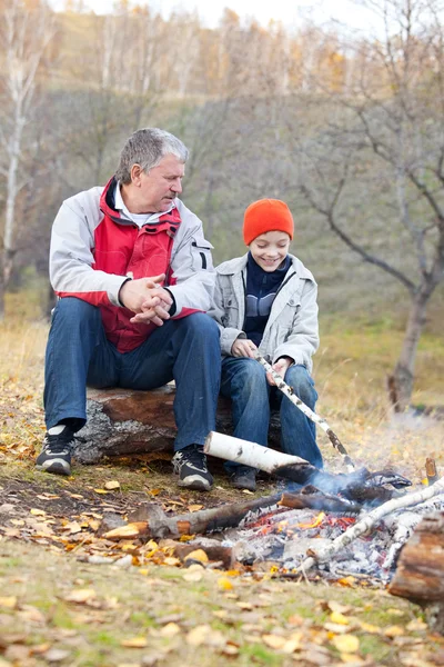 Dziadek i wnuczek przy ognisku — Zdjęcie stockowe