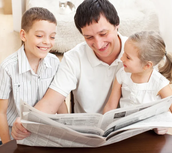Familia leyendo un periódico — Foto de Stock