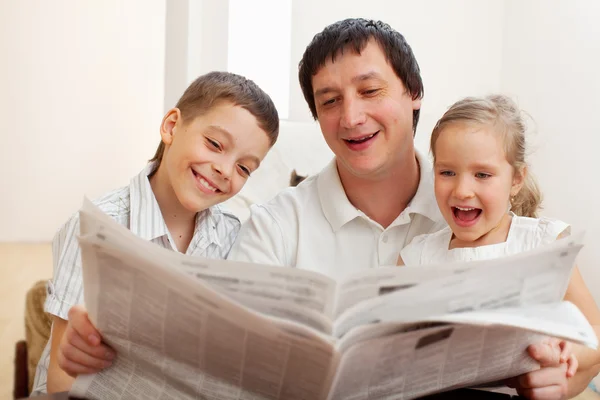Família lendo um jornal — Fotografia de Stock