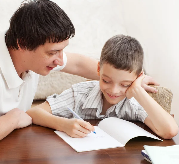 Ojciec pomoc syna zrobić pracę domową — Zdjęcie stockowe