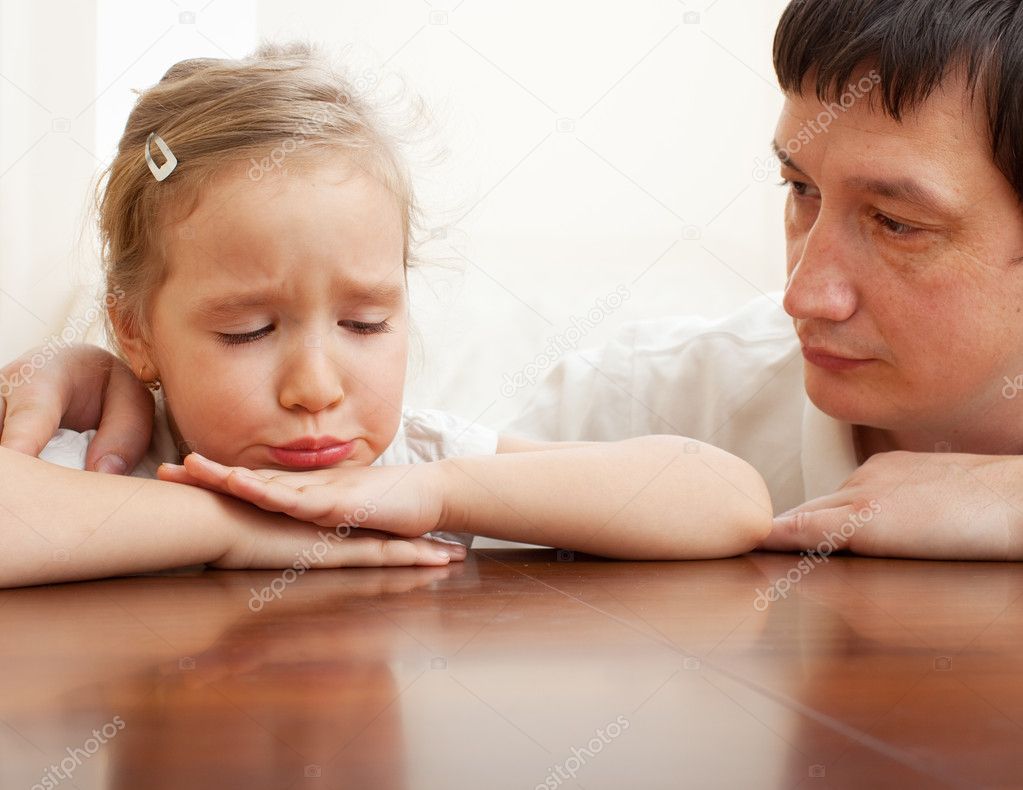 Father comforts a sad girl