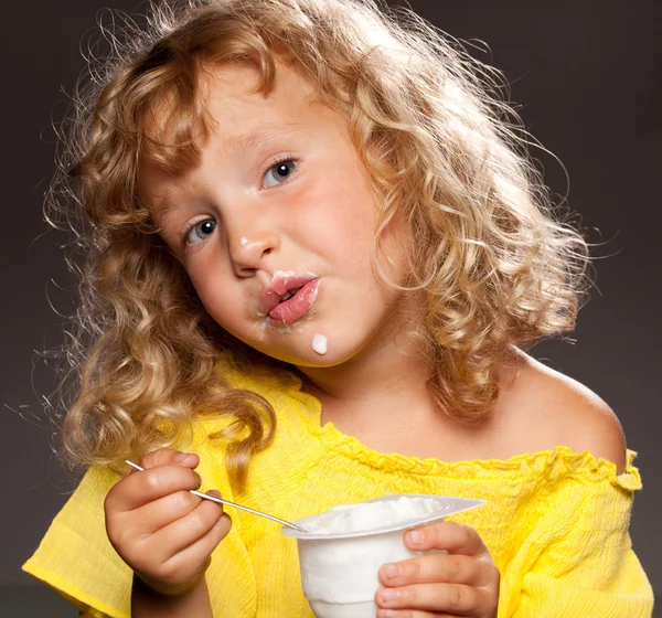 Little girl eating yogurt — Stock Photo, Image