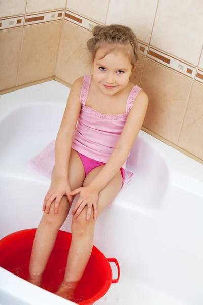 Meisje houden zijn voeten in koud water. harden — Stockfoto