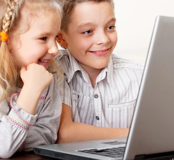Счастливые дети играют дома в ноутбук — стоковое фото
