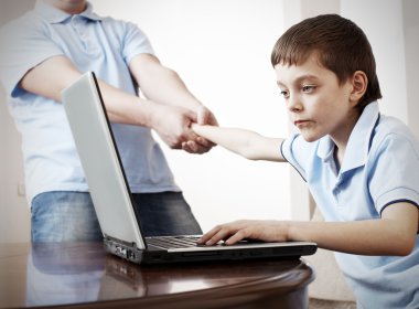 Father dragging son from the computer clipart