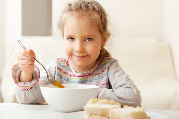 Маленькая девочка ест суп — стоковое фото
