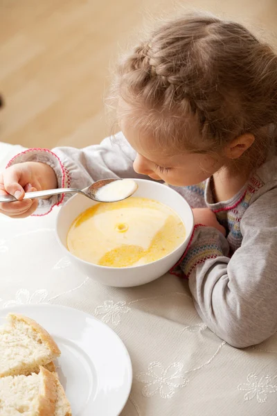 Liten flicka äter soppa — Stockfoto