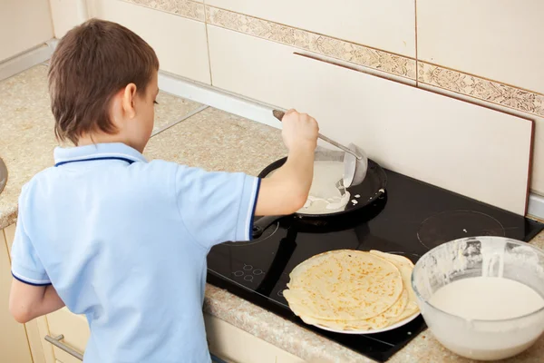 Kind bakt pannenkoeken — Stockfoto