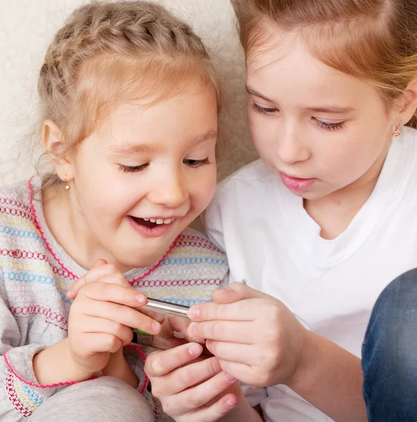 Verrast kinderen met mobiele telefoon — Stockfoto