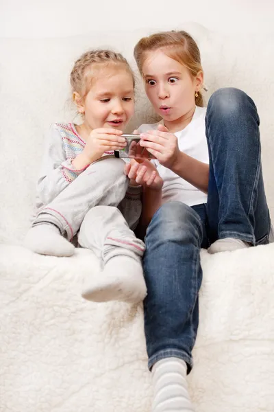 Удивленные дети с мобильным телефоном — стоковое фото