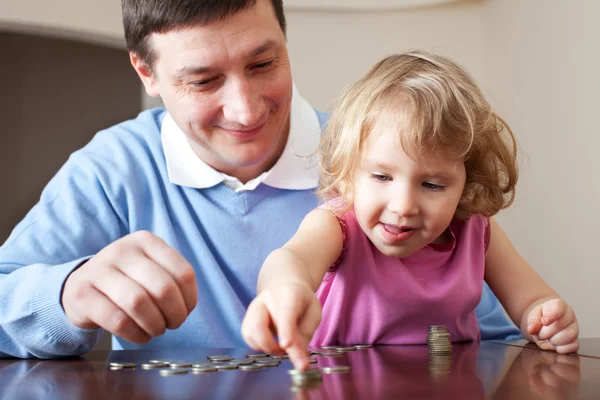 Папа и дочь ставят монеты — стоковое фото