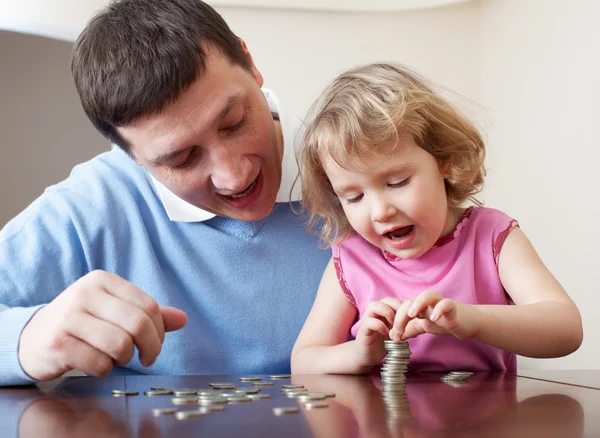 Otec a dcera klade mince — Stock fotografie