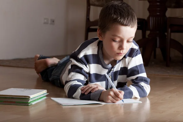 Oğlan yerde yatarken dersleri mı — Stok fotoğraf