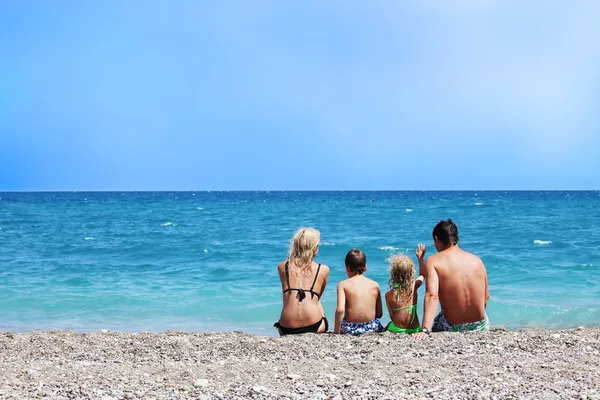 Família sentada na praia — Fotografia de Stock