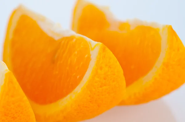 Segmentos frescos de uma laranja em um fundo branco — Fotografia de Stock