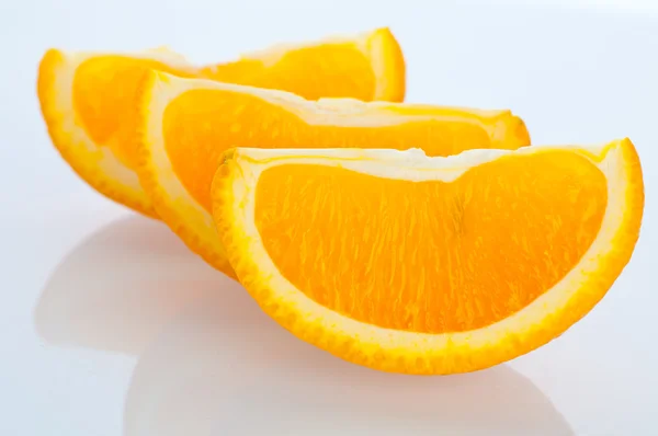 Segmentos frescos de uma laranja em um fundo branco — Fotografia de Stock