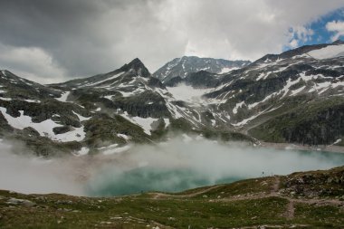 Alps near Wei§see with fog in Uttendorf clipart