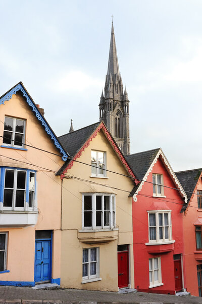 Terraced houses with the St. Colman's cathedral in the background. Cobh, County Cork, Ireland