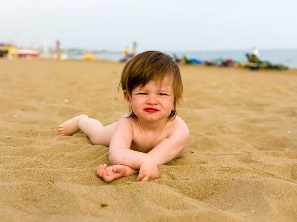 Menina da criança deitado na praia de areia — Fotografia de Stock