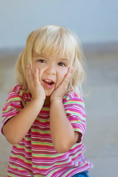 Маленька дівчинка в смугастій сукні позує обличчям — стокове фото