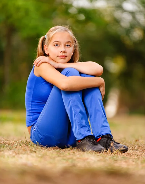 Nastoletnia Dziewczyna siedząca na zielony łąka — Zdjęcie stockowe