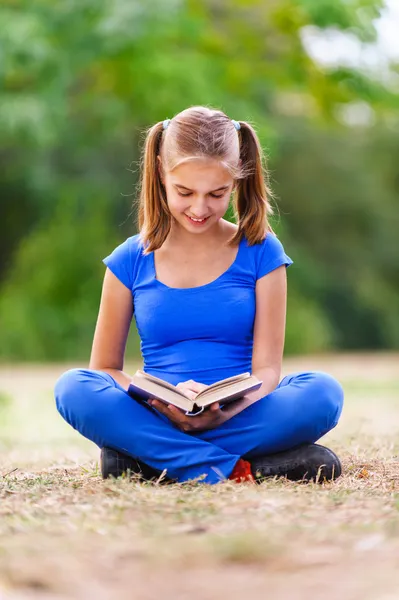 Девочка-подросток сидит и читает книгу — стоковое фото