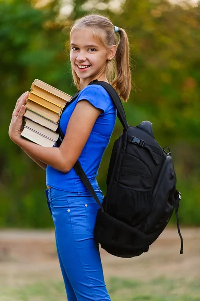 Teenager-Mädchen hält Stapel von sieben Büchern in der Hand — Stockfoto