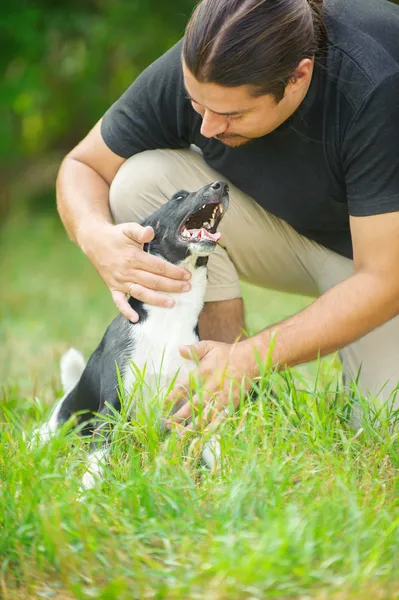 Dark-haired man stroked dog — Stock Photo, Image