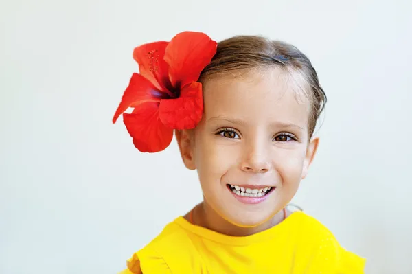 Petite fille en robe jaune avec fleur rouge — Photo