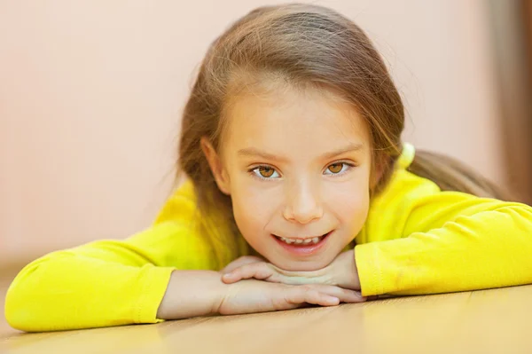 Dziewczynka w żółtej sukience leżącego na podłodze — Zdjęcie stockowe