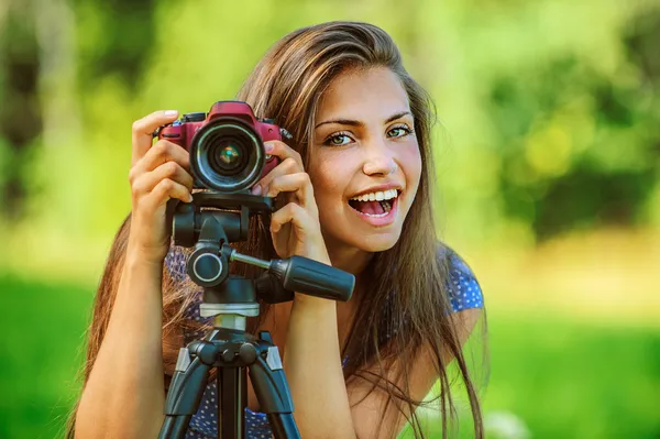 Hermosa mujer fotografiada con trípode de cámara — Foto de Stock