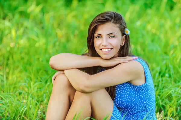 Женщина сидит на траве и улыбается — стоковое фото