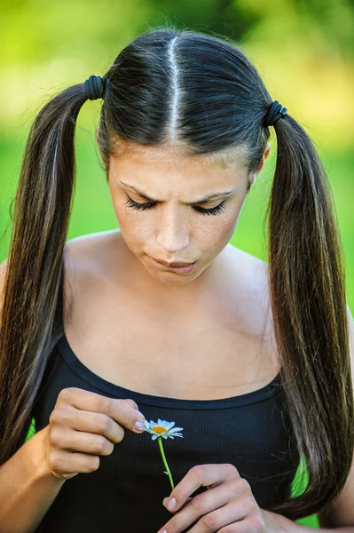 Frau fragt sich, reißt Blütenblätter auf Gänseblümchen — Stockfoto