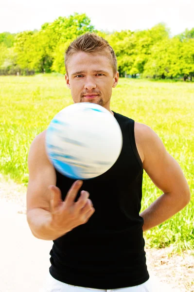 Homme courageux tourne sur son doigt volley-ball — Photo