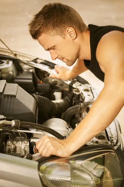 Молодий чоловік ремонтує автомобіль — стокове фото