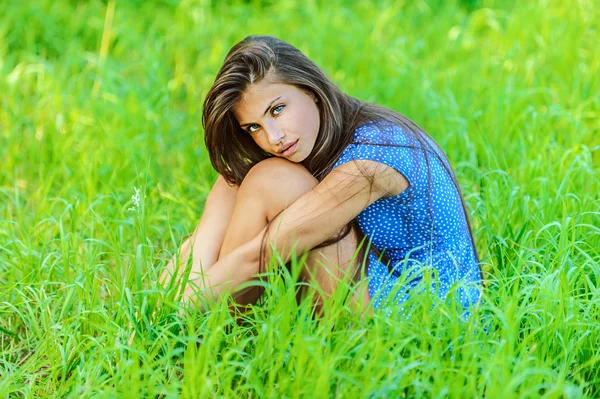 Portré, fiatal, gyönyörű nő ül a fűben — Stock Fotó