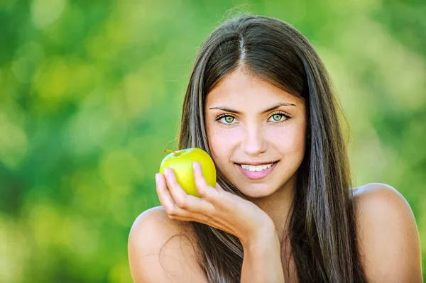 Женщина с голыми плечами держит яблоко — стоковое фото