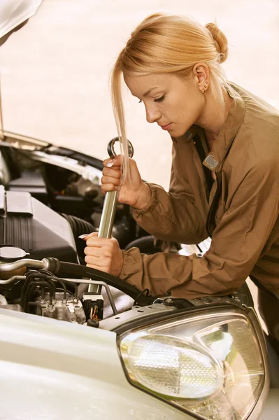 Mladá žena opravovat auto — Stock fotografie