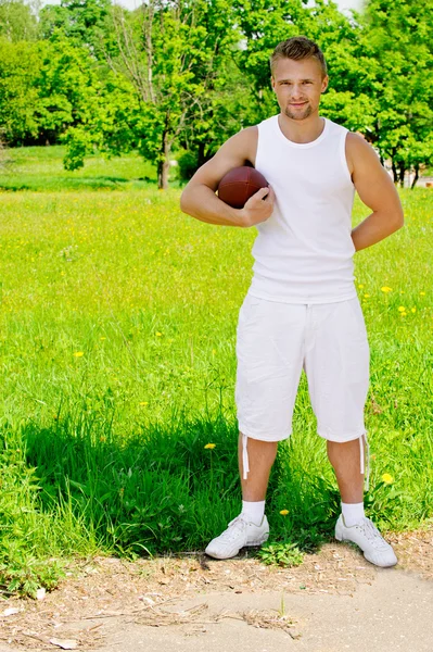 Красивый молодой спортсмен с мячом для регби — стоковое фото