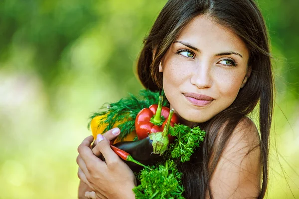 Frau mit nackten Schultern, die Gemüse hält Stockbild