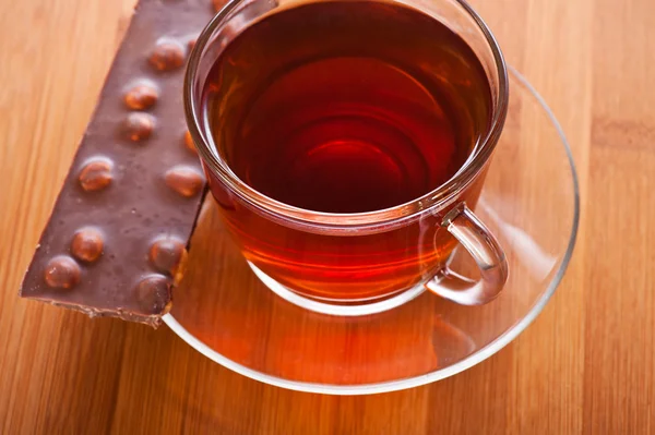 Pohár (čaj, káva) a kousek čokolády — Stock fotografie