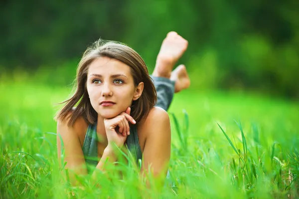 Ung flicka liggande på gräs drömmer — Stockfoto