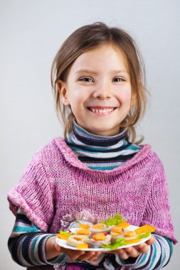 Girl holding plate of food clipart