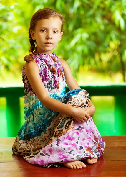 Κορίτσι που κάθεται στο ξύλινο τραπέζι — Φωτογραφία Αρχείου