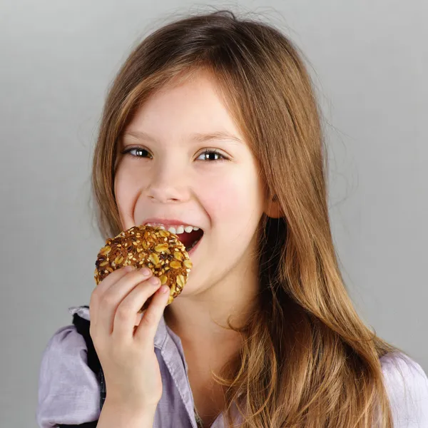 Retrato de criança (menina), morde biscoitos de aveia — Fotografia de Stock