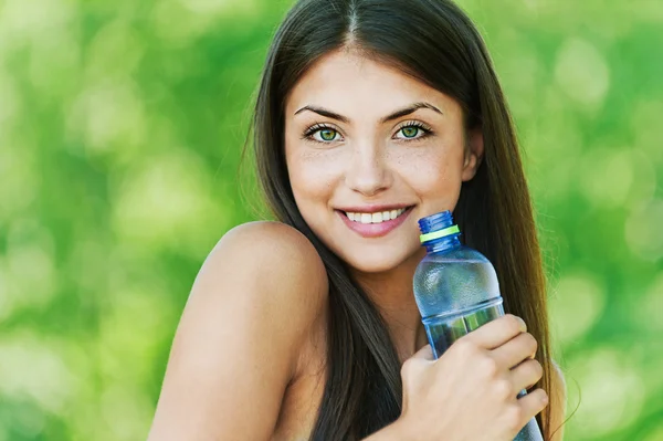 Vacker flicka med flaska vatten — Stockfoto
