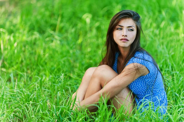 悲伤的女人坐在草地上 — 图库照片