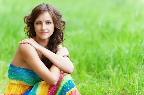 年轻漂亮的女人坐在草地上 — 图库照片