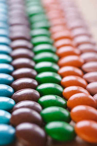 Doces de chocolate coloridos e redondos na cobertura — Fotografia de Stock