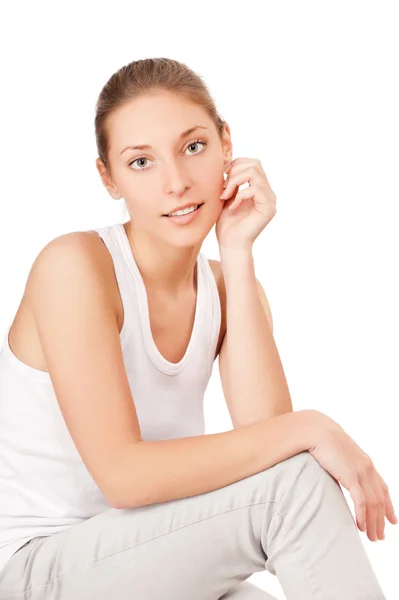 Bella giovane donna seduta sul pavimento isolata su sfondo bianco — Foto Stock